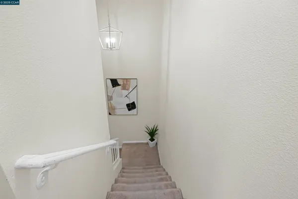 a view of a hallway with wooden floor and a bathroom