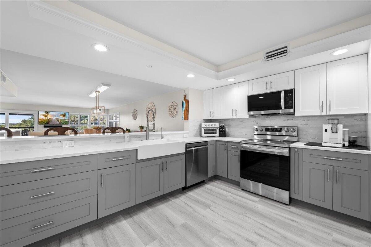 364 Golfview Road, Unit 405 North Palm Beach, FL 33408 - Photo 8 of 33 a large kitchen with stainless steel appliances granite countertop a stove and a sink