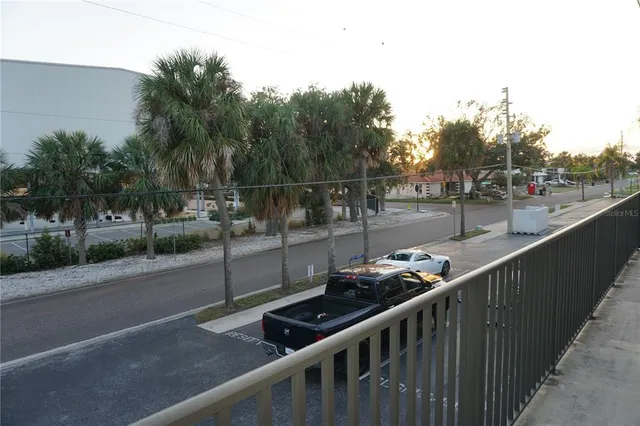 a view of a balcony with chairs and floor to ceiling window