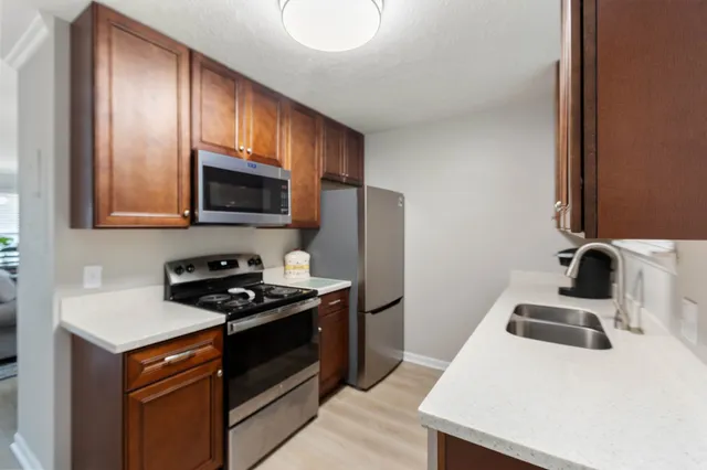 a kitchen with stainless steel appliances a stove a sink a microwave and cabinets