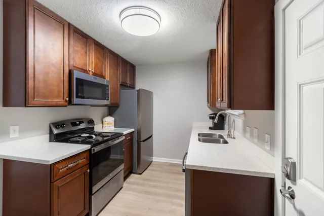 a kitchen that has a sink and a stove top oven