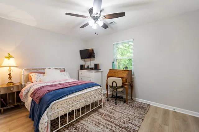 a bedroom with a bed a chandelier and a window