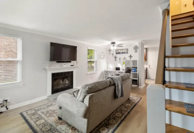 a living room with furniture a flat screen tv and a fireplace