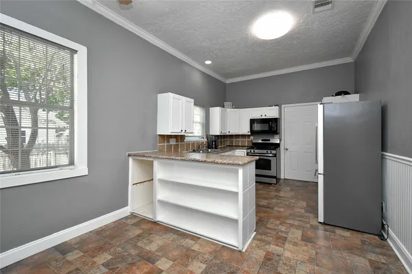 a kitchen with cabinets appliances and a window