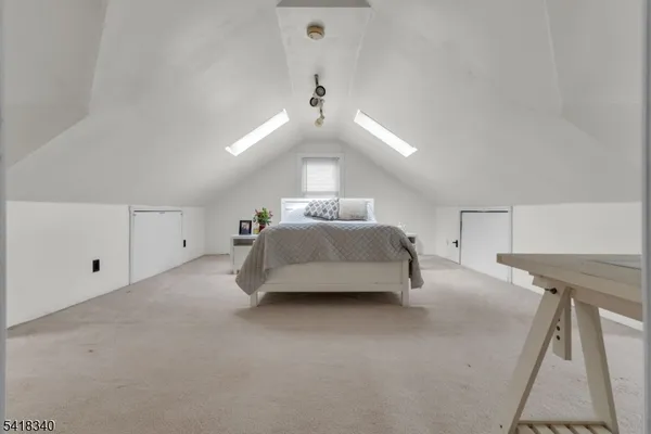 a spacious bedroom with a bed and a chandelier