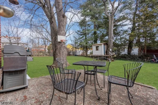 a view of a chair and table in backyard of the house