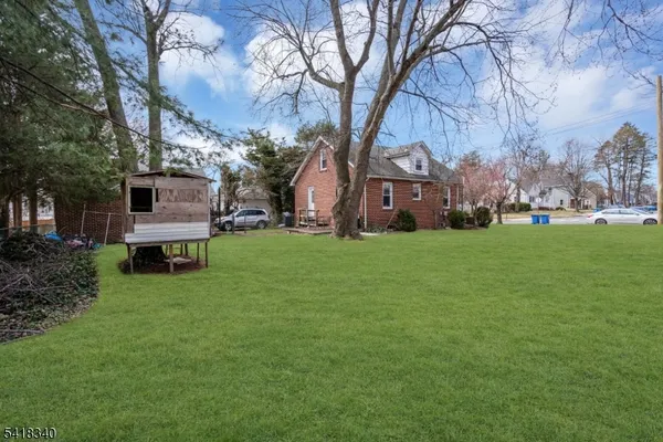 a front view of house with a garden and trees