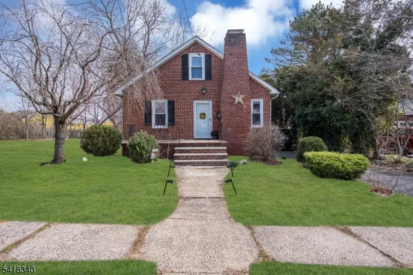 a front view of a house with a yard and green space