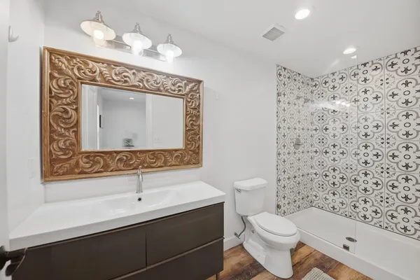 a bathroom with a toilet sink and mirror