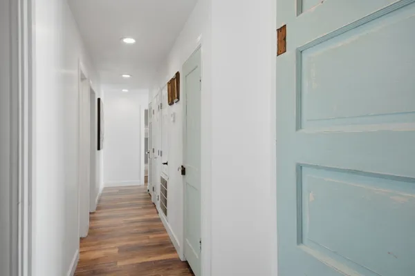 a view of a hallway with wooden floor and staircase