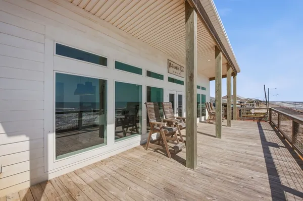 a view of a patio with wooden floor and iron fence