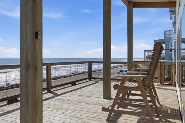 a view of a balcony with chairs and wooden floor