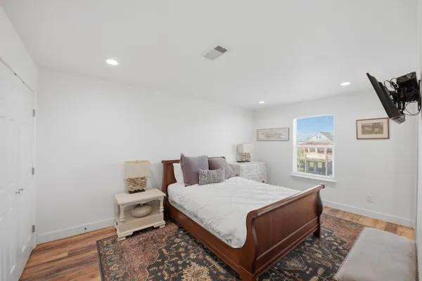 a bedroom with a bed and wooden floor