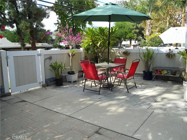 a patio with a table and chairs under an umbrella