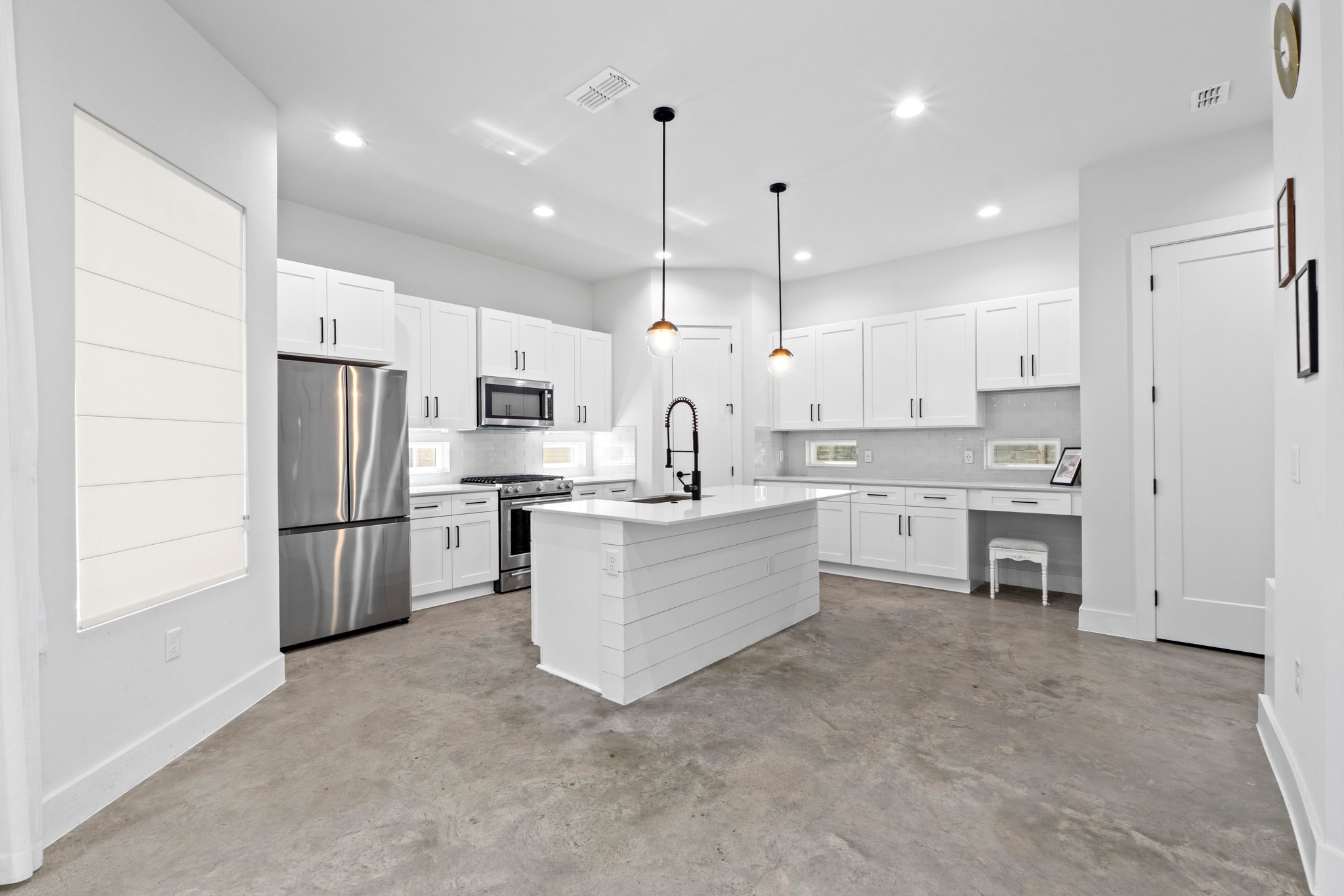 2007 Chestnut Avenue, Unit 1 Austin, TX 78722 - Photo 9 of 32 A streamlined kitchen design features sleek white cabinetry and a functional island, creating an inviting culinary space.