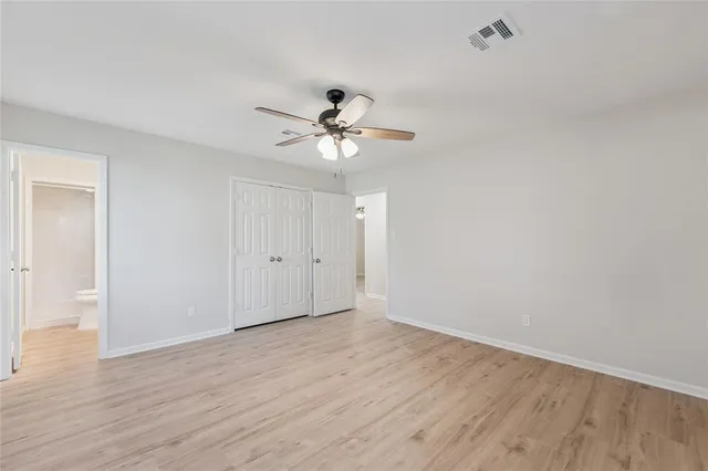 a view of a room with wooden floor and a ceiling fan