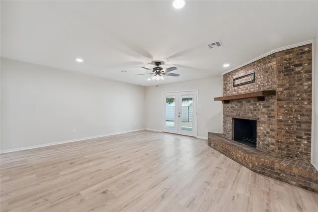 a view of an empty room with a fireplace and a window