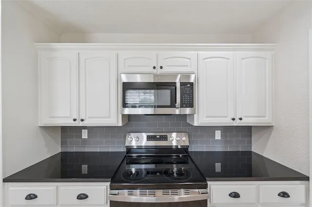 a white stove top oven sitting inside of a kitchen