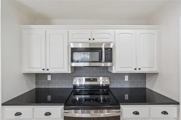 a white stove top oven sitting inside of a kitchen