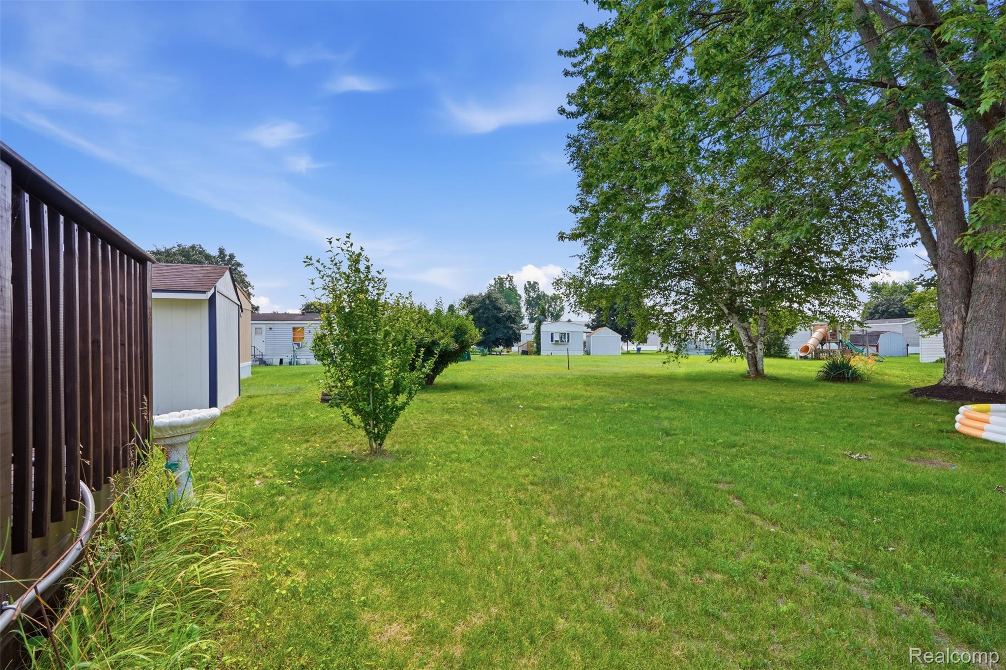 4634 Butternut Street Clarkston, MI 48348 - Photo 23 of 28 Expansive green lawn with mature trees providing natural shading