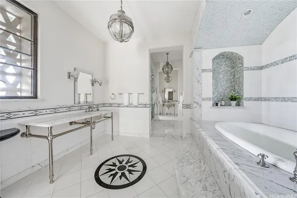 a bathroom with a tub sink and mirror