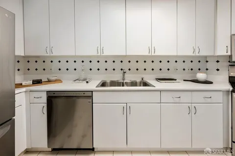 a kitchen with granite countertop white cabinets and sink