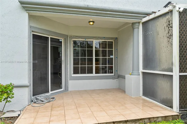 a view of an empty room with a window and potted plants