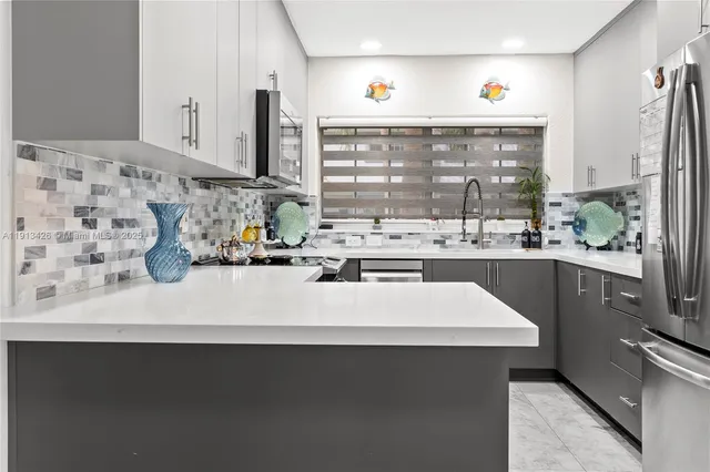 a kitchen with kitchen island a sink a stove and a window