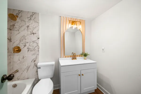 a bathroom with a sink mirror vanity and toilet