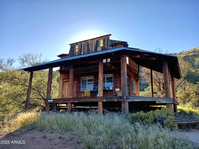 a view of house with a large window and potted plants