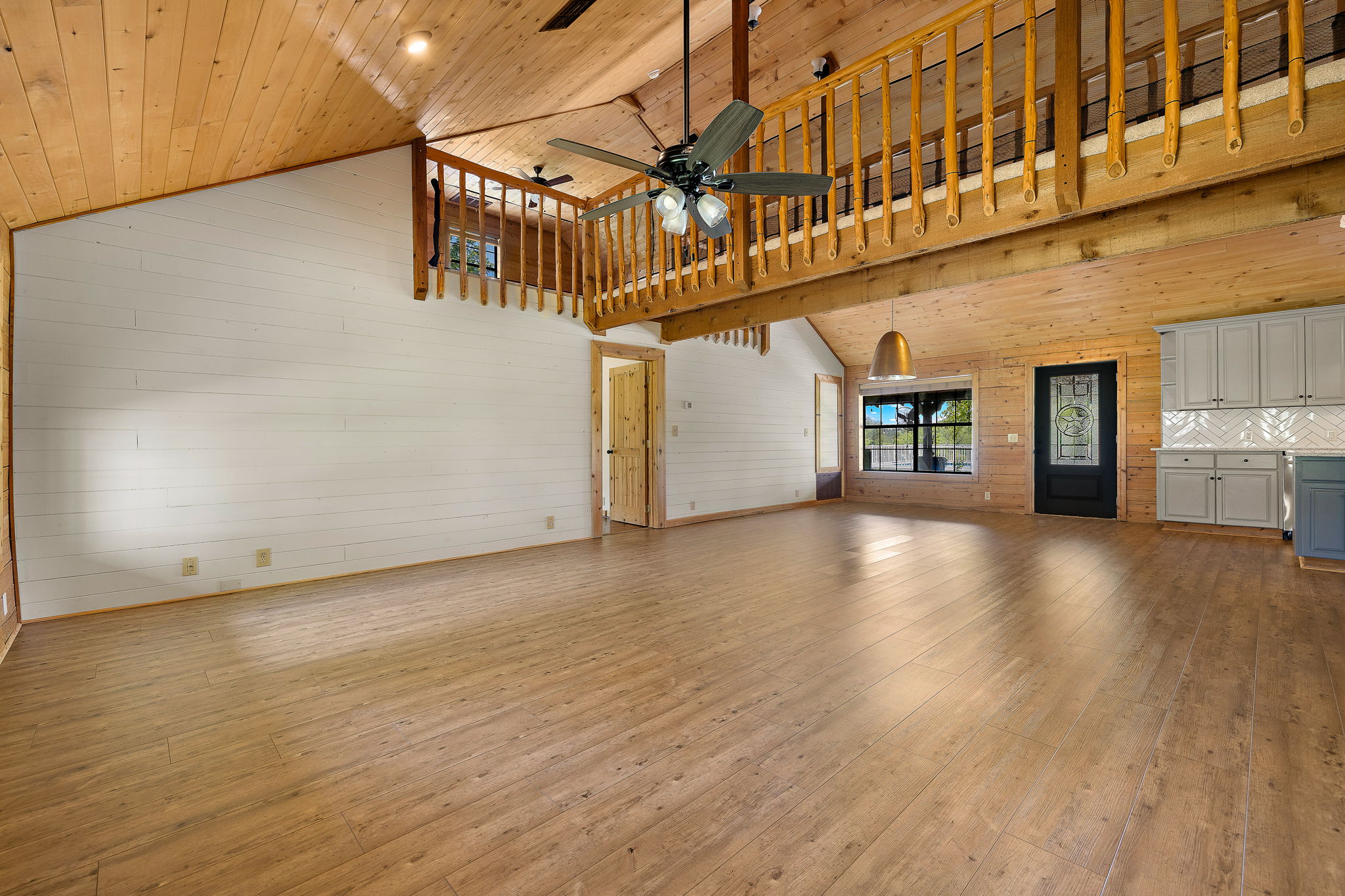 571 Balch Road Elgin, TX 78621 - Photo 7 of 33 Open concept living space featuring wood-finish flooring, a vaulted wood-paneled ceiling, and a prominent loft with wooden railing