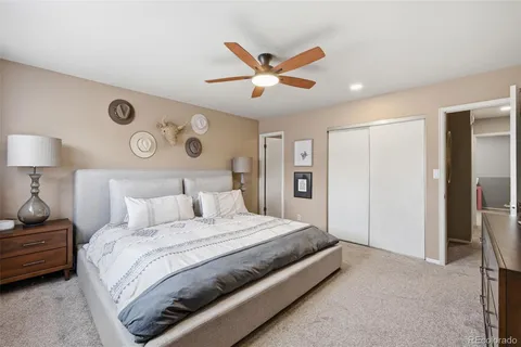 a bedroom with a bed and a ceiling fan