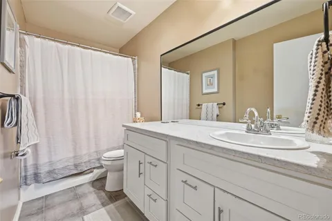 a spacious bathroom with double vanity and a mirror