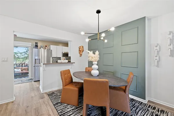 a dining room with furniture a chandelier and wooden floor