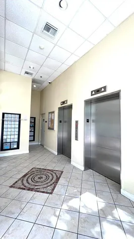 a view of a refrigerator in kitchen and an empty room