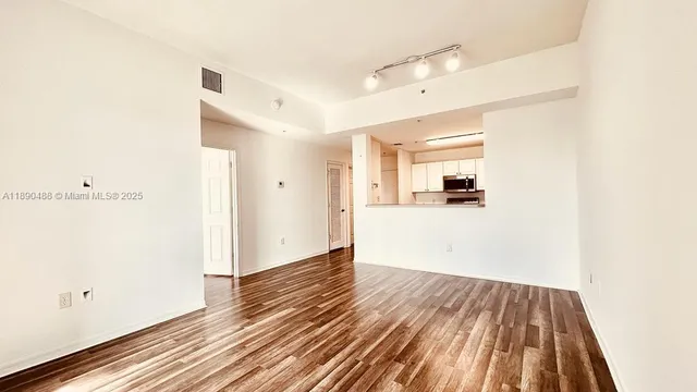 a view of a room with wooden floor and a ceiling fan
