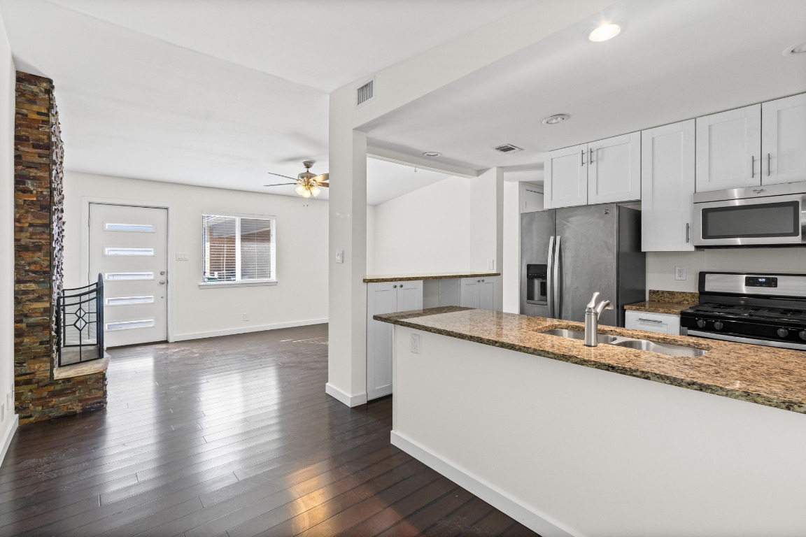 a kitchen with stainless steel appliances granite countertop a sink refrigerator and cabinets