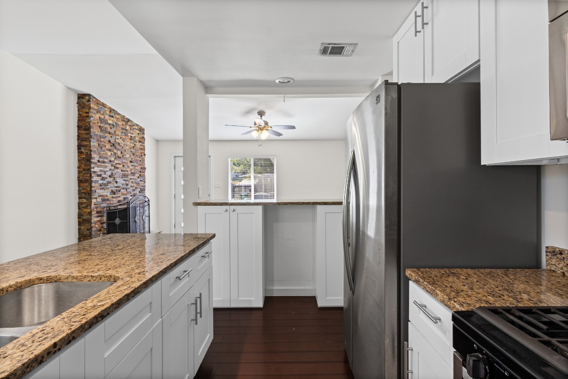 6305 Vioitha Drive, Unit B Austin, TX 78723 - Photo 10 of 23 a kitchen with stainless steel appliances granite countertop a refrigerator and a sink
