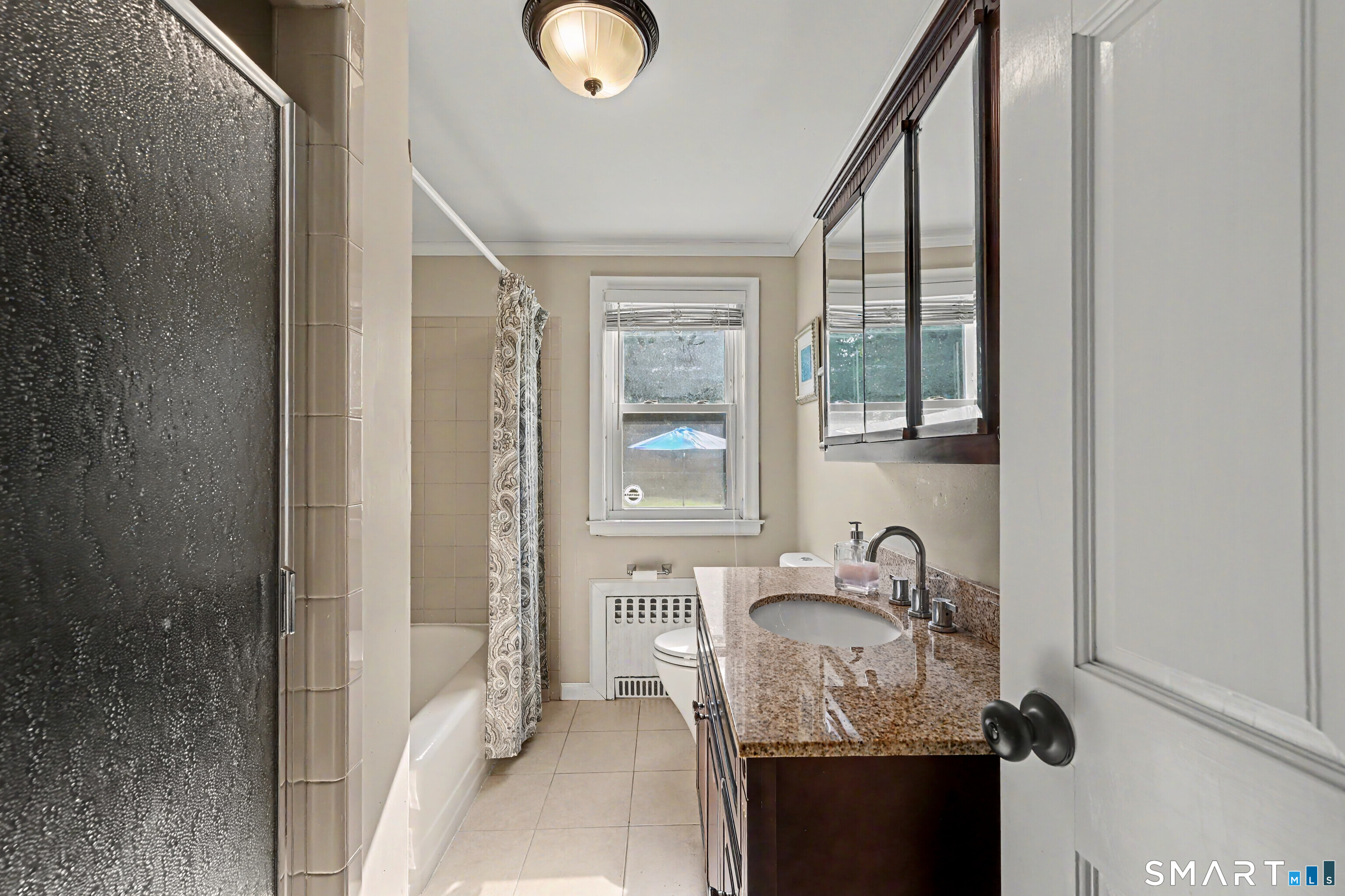 524 Ferry Road Orange, CT 06477 - Photo 26 of 40 a bathroom with a granite countertop sink a mirror and a shower