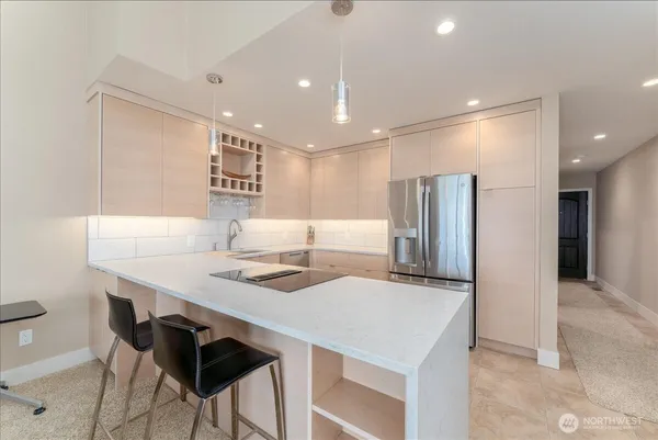 a kitchen with stainless steel appliances kitchen island a table chairs in it and wooden floors