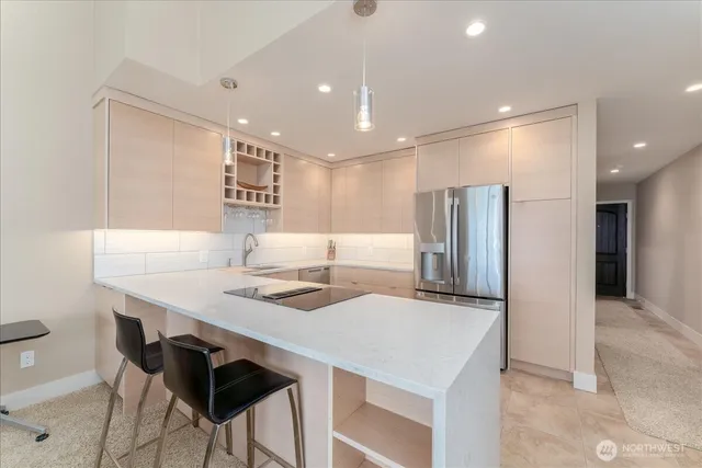 a kitchen with stainless steel appliances kitchen island a table chairs in it and wooden floors