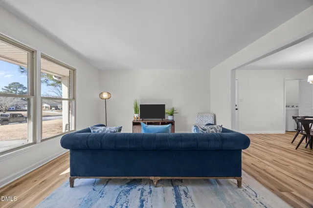 a living room with furniture and a wooden floor