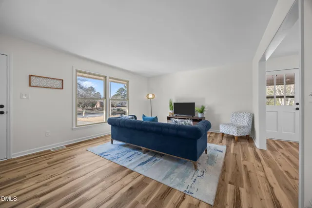 a living room with furniture and a wooden floor