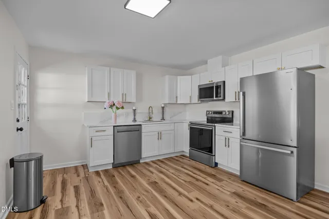 a kitchen with a sink cabinets stainless steel appliances and a window