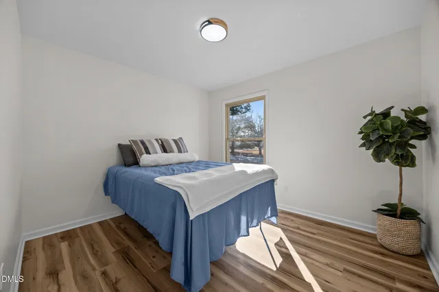 a bedroom with bed and a potted plant