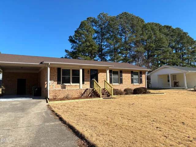 a front view of a house with a yard and seating space