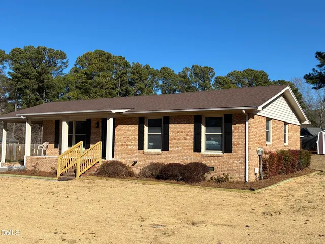 a front view of a house with a yard covered with snow in front of house