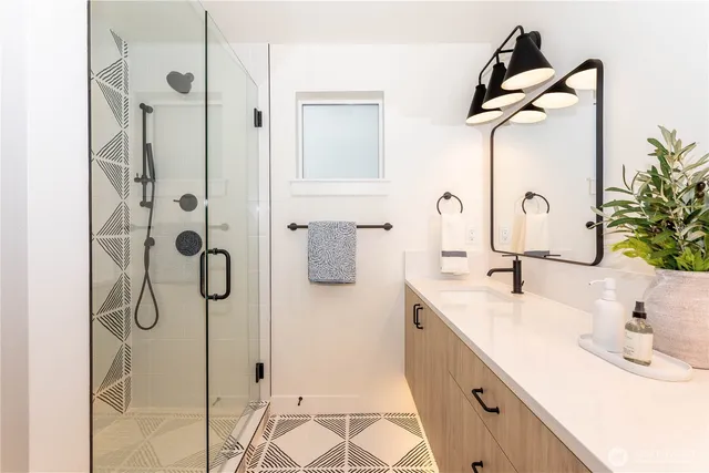 a bathroom with a double vanity sink a mirror and shower