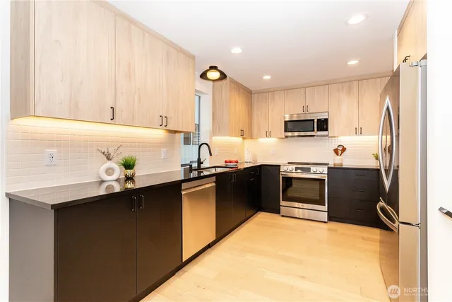 a kitchen with kitchen island granite countertop a sink appliances cabinets and furniture