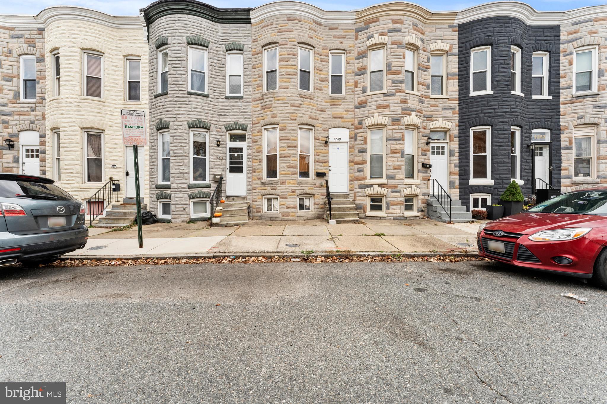 1249 Carroll Street Baltimore, MD 21230 - Photo 1 of 29 a view of a white apartments with large windows and cars parked